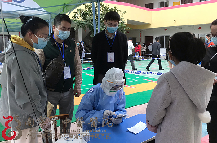 南宁市中医医院信息科陈龙（左三）在核酸检测点驻点工作中.jpg