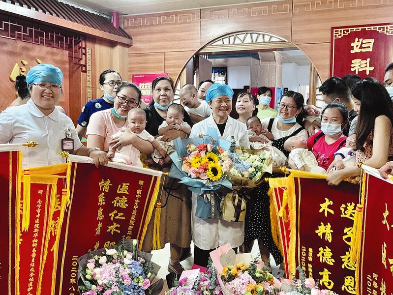 成功孕育生命的妈妈们带着锦旗和鲜花向新华妇科团队致谢。.jpg